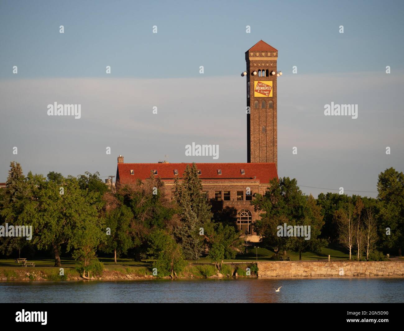 Das historische Wahrzeichen Chicago, Milwaukee und St. Paul Personenzugdepot in Great Falls, Montana, fotografiert in goldenem Licht mit Bäumen und dem Mi Stockfoto