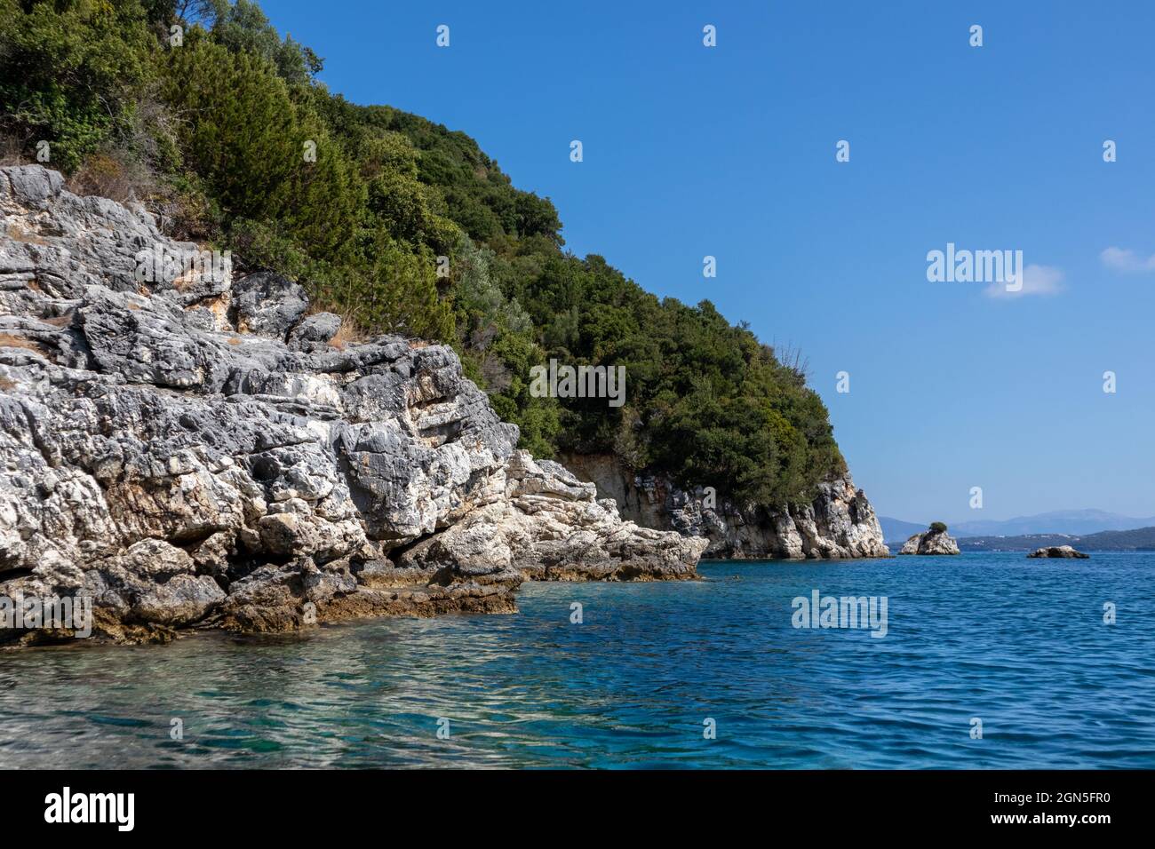 Blaues sonniges Ionisches Meer mit landschaftlich schönen grünen Felsklippen und hellem Himmel. Natur der Insel Lefkada in Griechenland. Sommerurlaub idyllisch Ormos Desimi tr Stockfoto