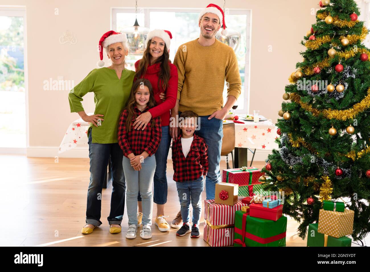 Glückliche, mehrfache Generation kaukasische Familie, die Foto mit weihnachtsbaum macht Stockfoto