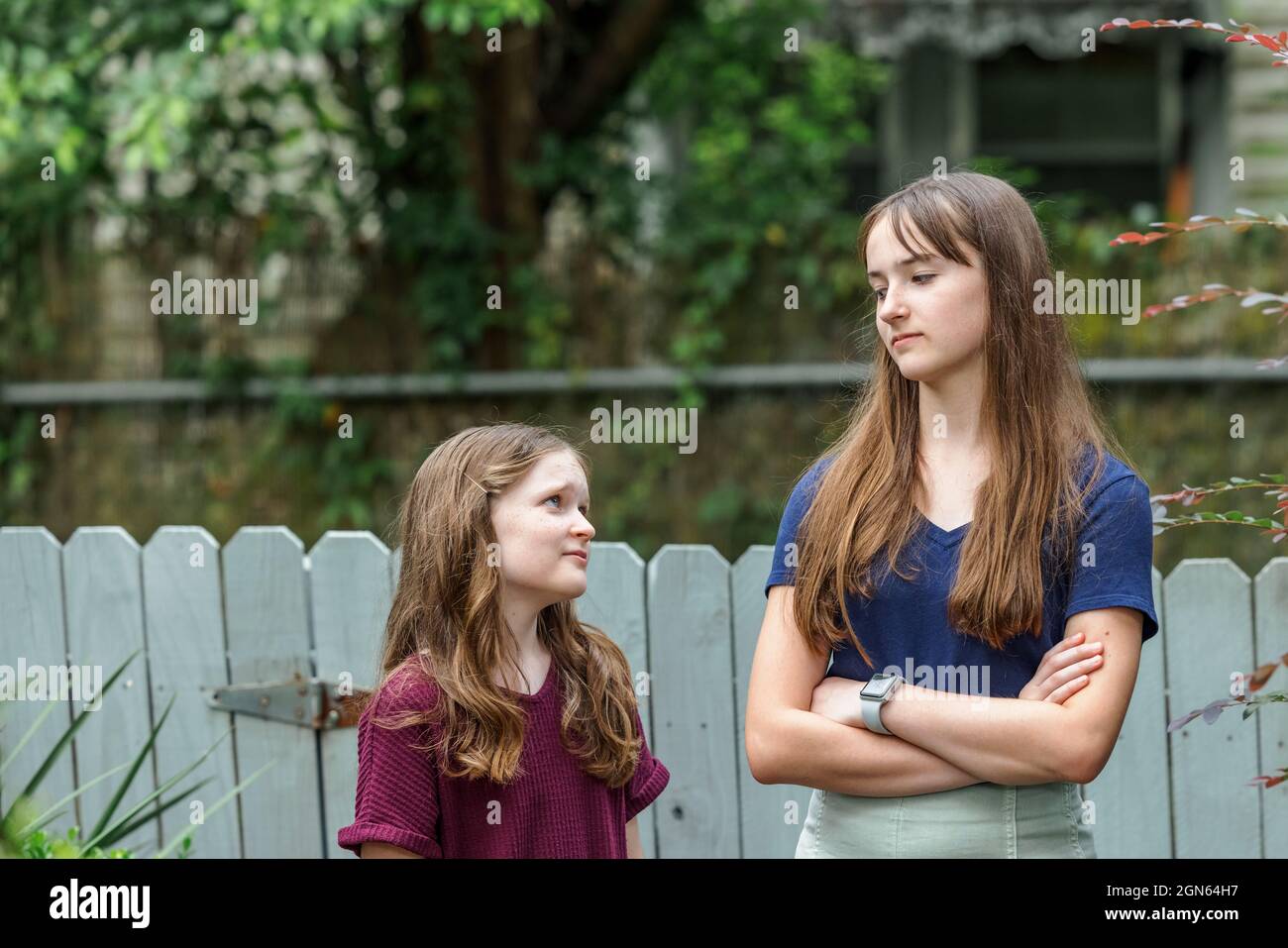Zwei Schwestern und eine davon ist ein Teenager, der mit ihrer kleinen Schwester nicht glücklich ist Stockfoto