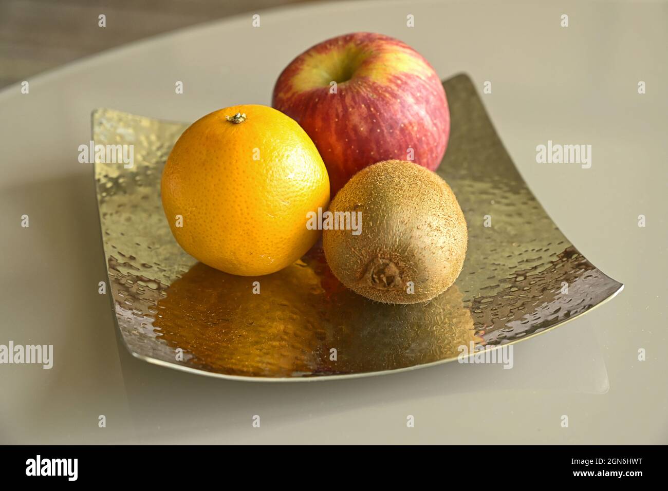 Stillleben aus Früchten. Apfel-, Orange- und Kiwi-Früchte auf einer Metallplatte. Stockfoto
