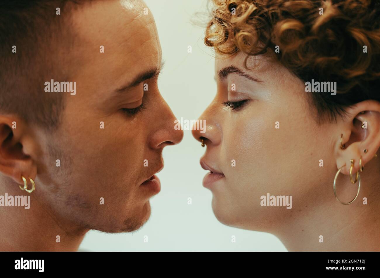 Junges Paar, das sich küsst. Liebevolles junges queeres Paar, das mit geschlossenen Augen dicht beieinander steht. Junge LGBTQ+ Paare teilen sich eine r Stockfoto