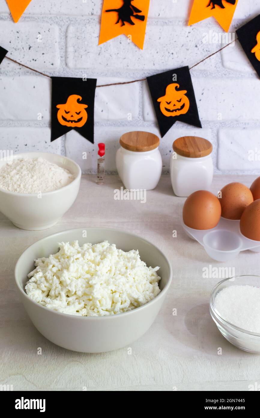 Schritt-für-Schritt Zubereitung von Hüttenkäse-Muffins für Halloween. Eine Reihe von Zutaten: Quark, Eier, Zucker, Mehl. Süße Cupcakes mit Monste Stockfoto