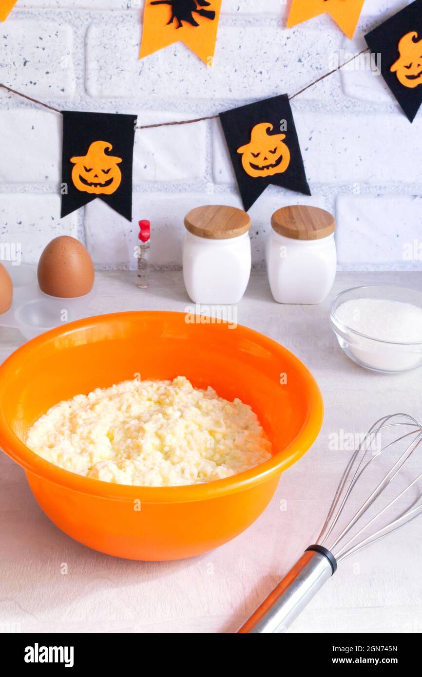 Schritt-für-Schritt Zubereitung von Hüttenkäse-Muffins für Halloween. Süße Cupcakes mit Monstern für Kinder. Mischung von Zutaten: Quark, Eier, Stockfoto