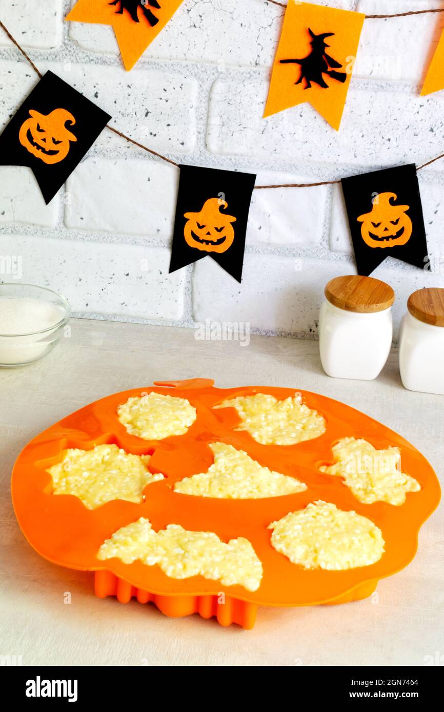 Schritt-für-Schritt Zubereitung von Hüttenkäse-Muffins für Halloween. Süße Cupcakes mit Monstern für Kinder. Geben Sie den Quark in eine Silikonbackform. Stockfoto