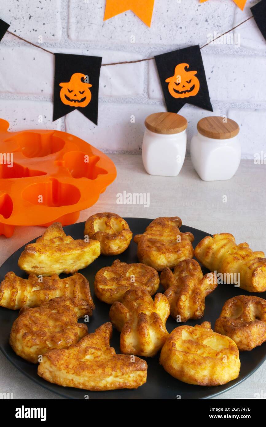 Schritt-für-Schritt Zubereitung von Hüttenkäse-Muffins für Halloween. Süße Cupcakes mit Monstern für Kinder. Legen Sie die Muffins auf einen Teller. Sie sollten es bekommen Stockfoto