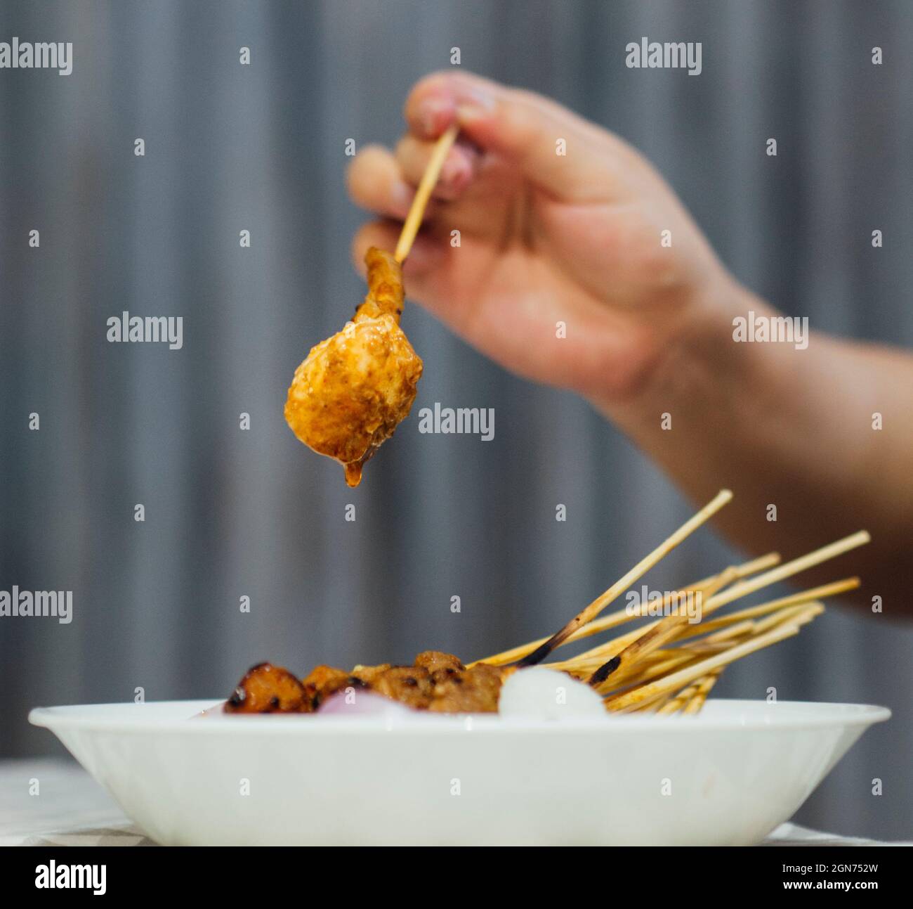 Satay auf Stick mit Reis Hand hält Ketupat Stockfoto