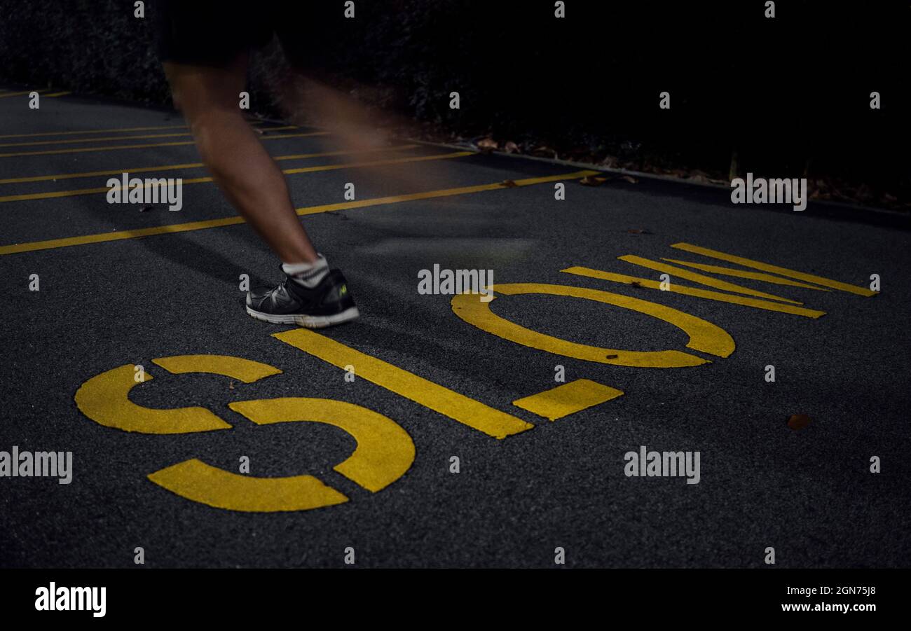 Schneller Lauf über langsames Schild auf dem Bürgersteig Stockfoto