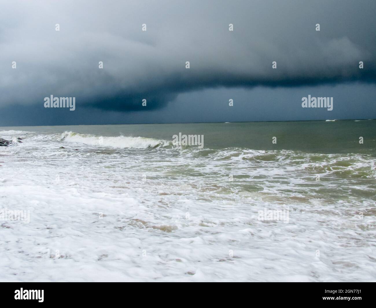 Dunkle Regenfälle und Sturmwolken bilden sich über dem Meerwasser Stockfoto