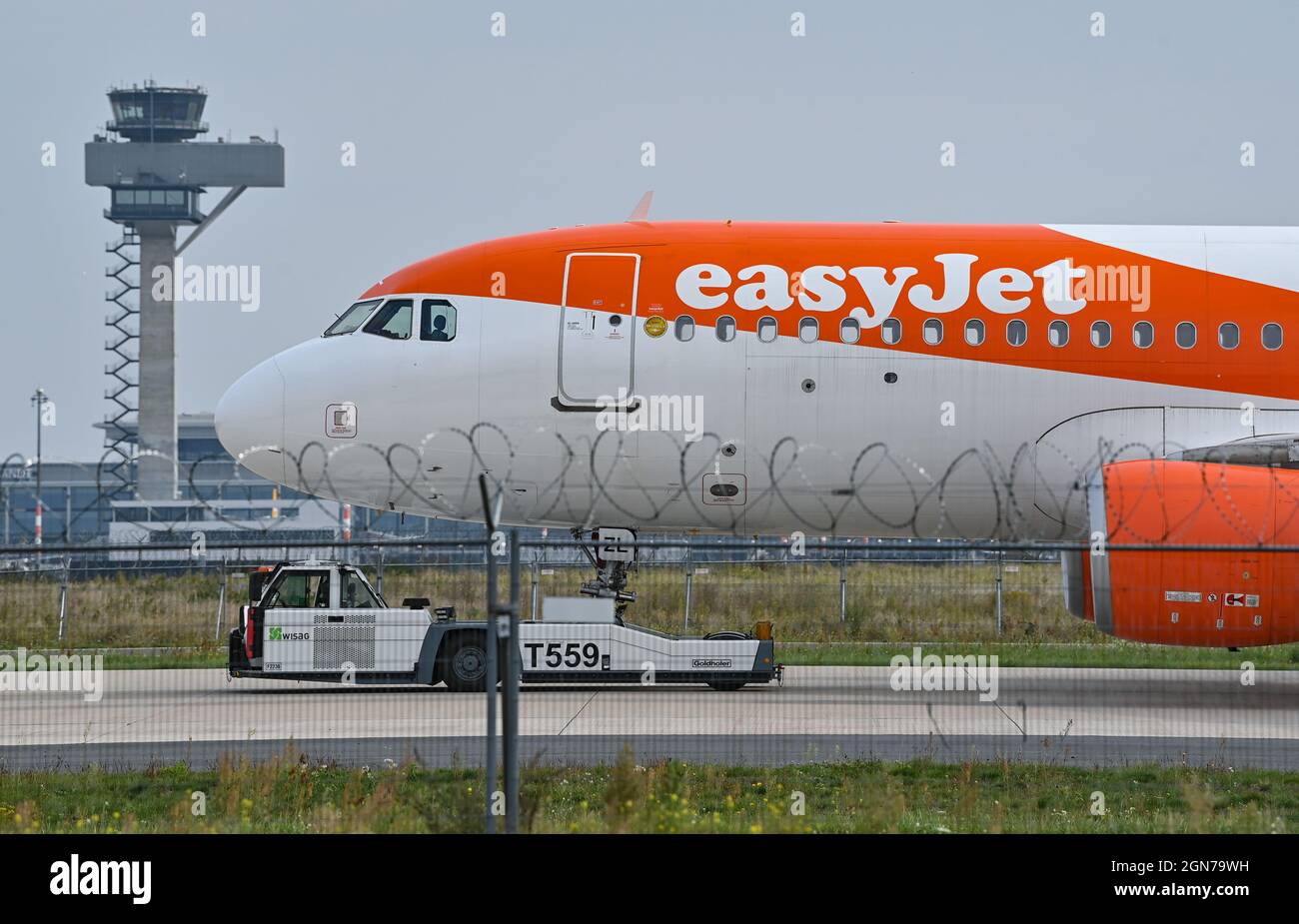 23. September 2021, Brandenburg, Schönefeld: Ein Passagierflugzeug der Fluggesellschaft easyJet steht auf dem Asphalt zum Spatenstich für einen easyJet-Hangar am Flughafen BER der Hauptstadt. Das Unternehmen easyJet baut am Flughafen BER einen neuen, 10,000 Quadratmeter großen Wartungshangar, in dem bis zu vier A321-Flugzeuge gleichzeitig untergebracht werden können. Dort sollen bereits Anfang 2023 Wartungsarbeiten durchgeführt werden. Das Brandenburgische Wirtschaftsministerium hat das Unternehmen bei der Investitionsentscheidung unterstützt, die über 31 Millionen Euro wert ist. Eine Anwendung für Spaß Stockfoto