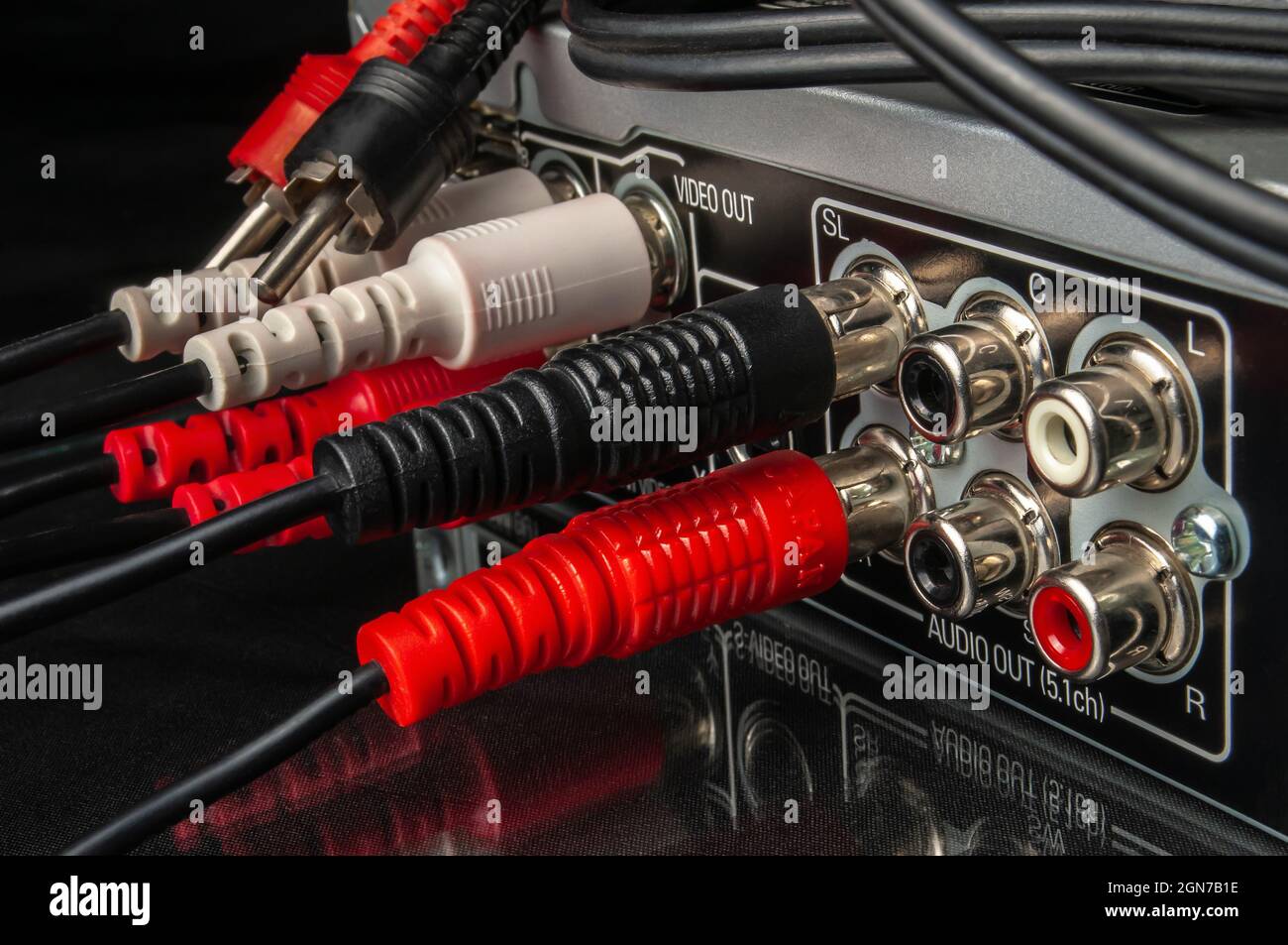 Moderne Multimedia- und Audiogeräte mit angeschlossenen Kabeln auf schwarzem Hintergrund, Nahaufnahme Stockfoto