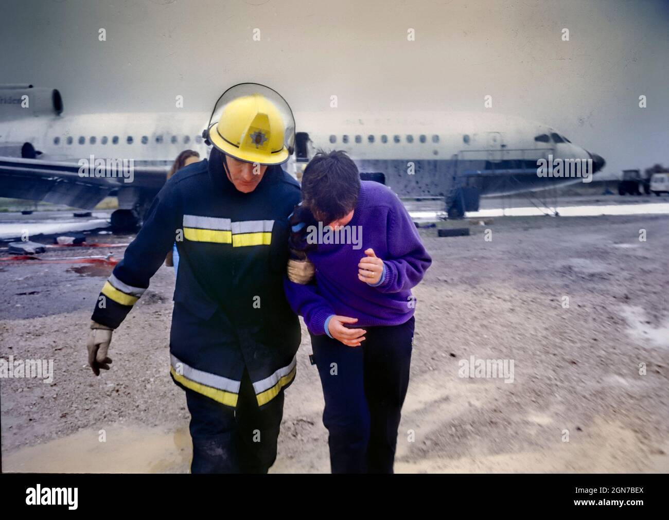 Feuerwehrleute und Sanitäter, die während einer Schulung und Koordinationsübung am Flughafen Manchester Freiwillige mit simulierten Verletzungen besuchen. Stockfoto