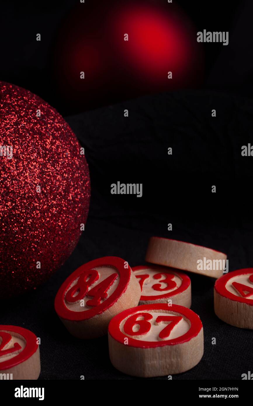 Rote weihnachtskugeln und Bingozahlen auf schwarzem Hintergrund Stockfoto