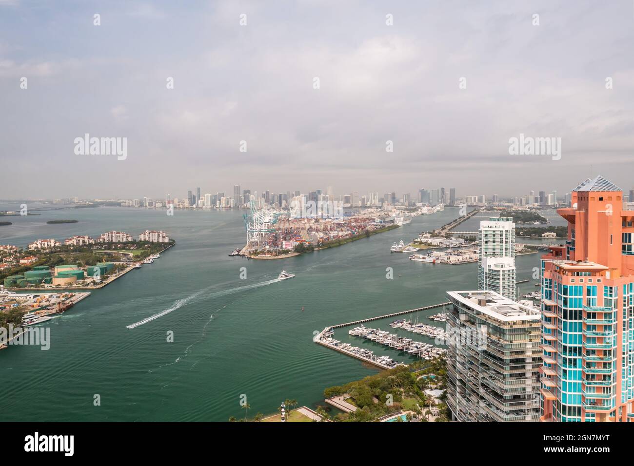 Unglaubliche Luftaufnahme über die Miami Schifffahrtskanäle mit der Skyline am Horizont und bewölktem Himmel über den Booten und Fähren. Stockfoto