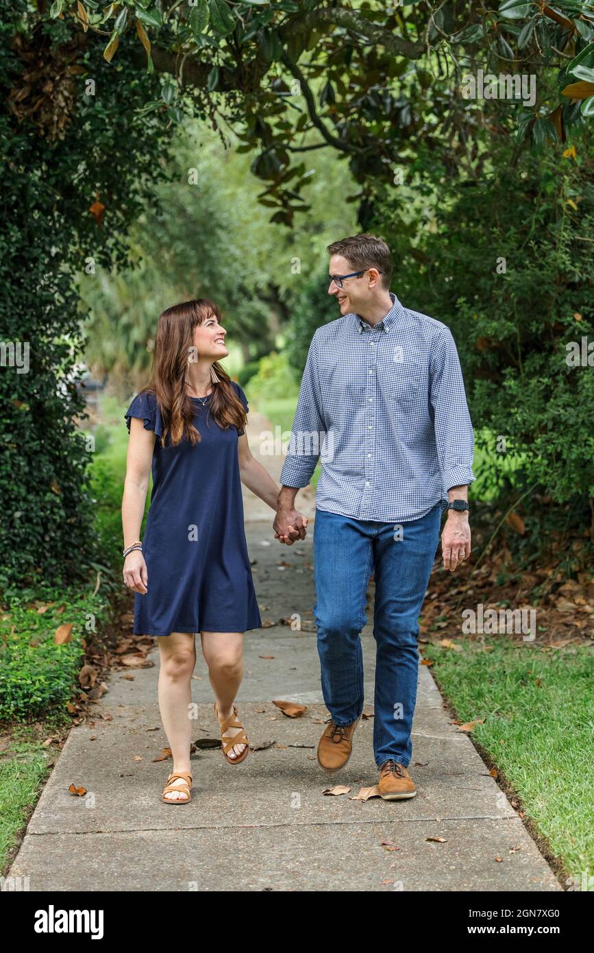 Ein Paar in den Vierzigern, die Eltern sind, machen einen romantischen Spaziergang und entfachen ihre Beziehung Stockfoto