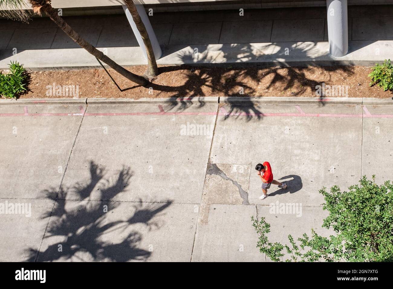 NEW ORLEANS, LA, USA - 10. JUNI 2021: Ein Mann, der mit Schatten mitten auf der Straße läuft Stockfoto