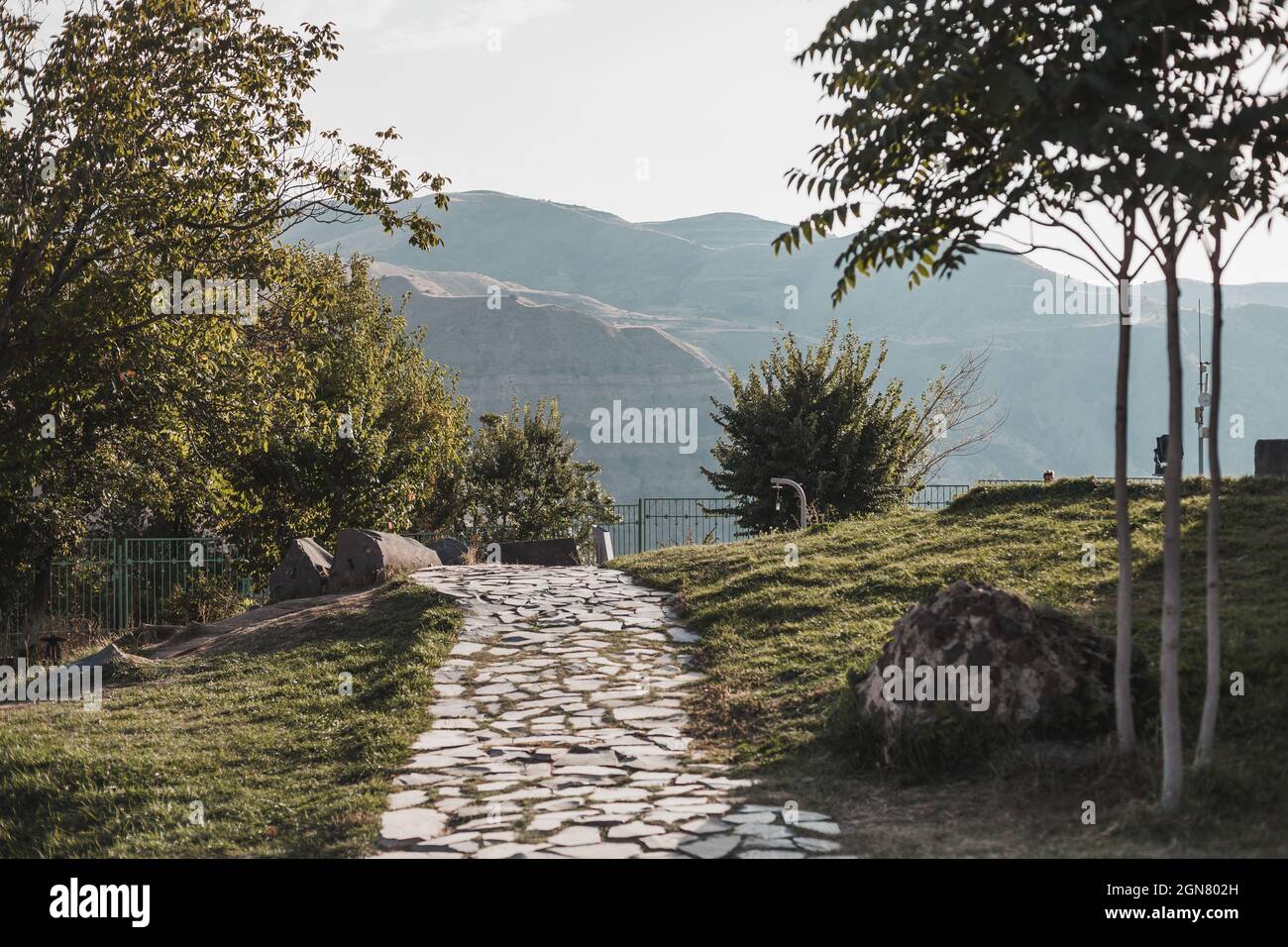 Pfad im Park mit Blick auf die Berge in der Stadt in Armenien. Malerischer Blick auf die Berge bei Sonnenaufgang. Tourismus in Armenien. Hochwertige Fotos Stockfoto