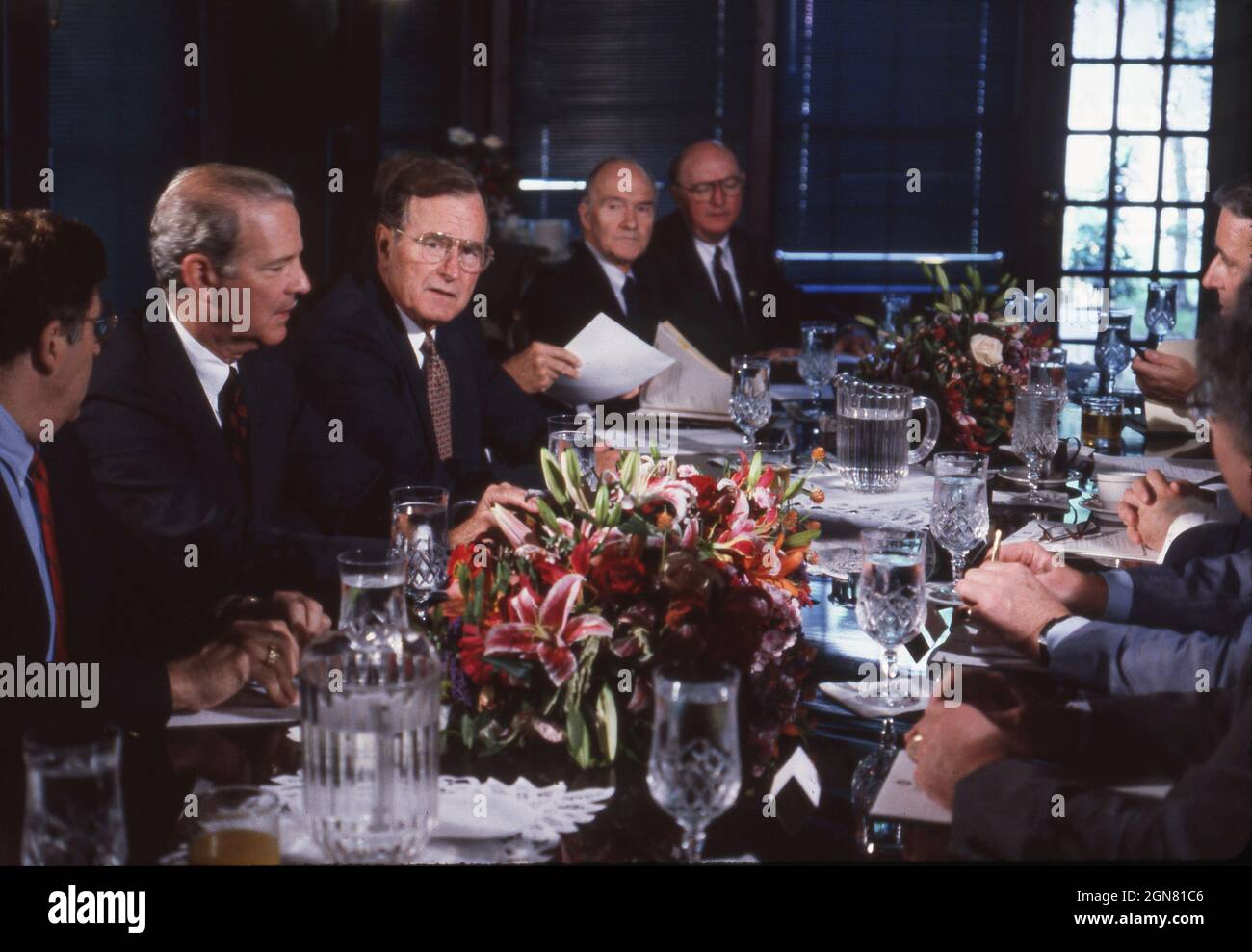 Houston, Texas, USA, Juli 1990: US-Präsident GEORGE W. BUSH (c) und Außenminister JAMES BAKER (l) veranstalten während des Wirtschaftsgipfels für Industrieländer an der Universität von Reis ein Arbeitsessen mit anderen Weltführern. ©Bob Daemmrich Stockfoto