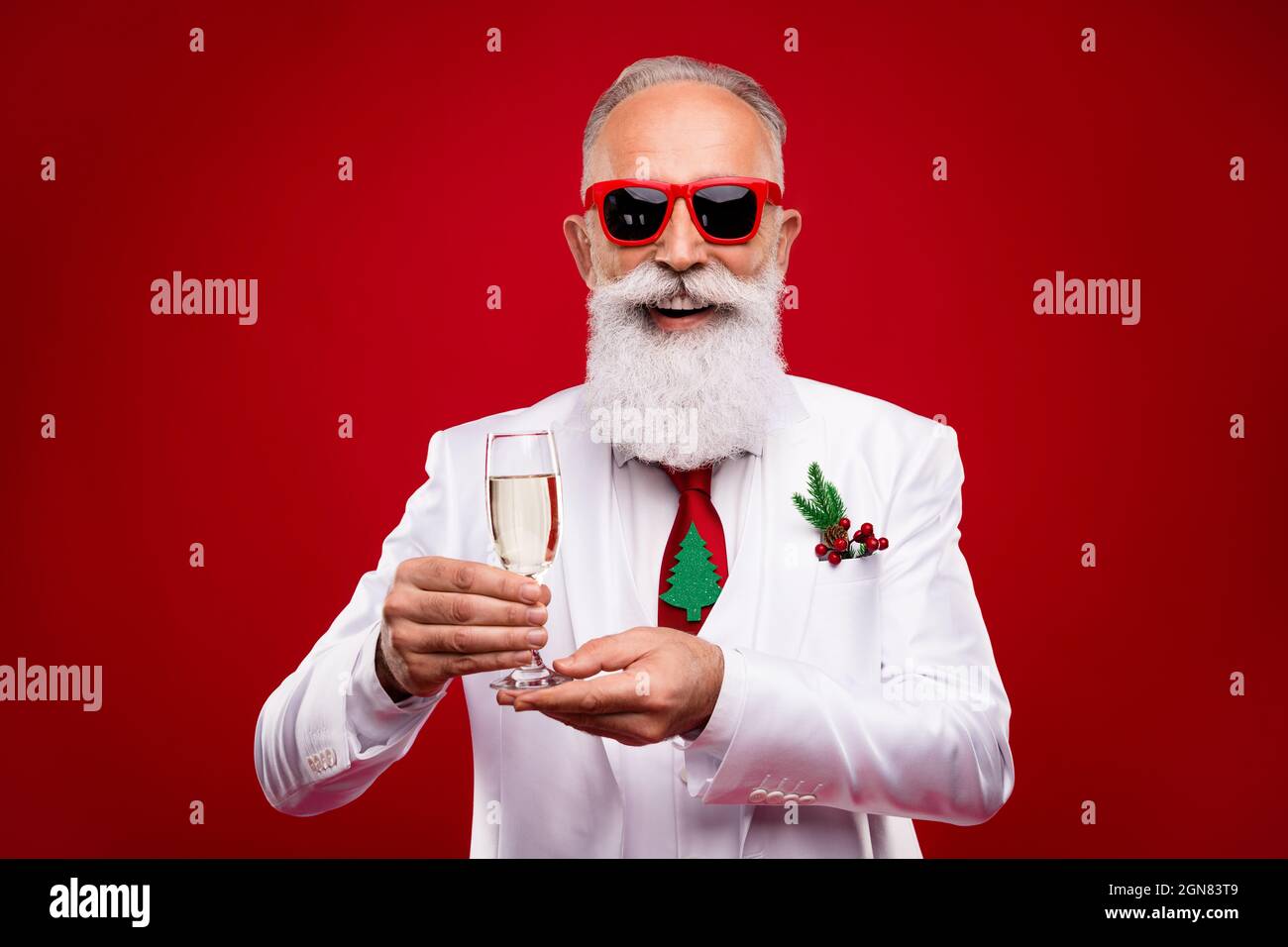 Foto von charmanten glücklich positive Mann halten Hände Champagner Glas Lächeln Weihnachten isoliert auf rotem Hintergrund Stockfoto