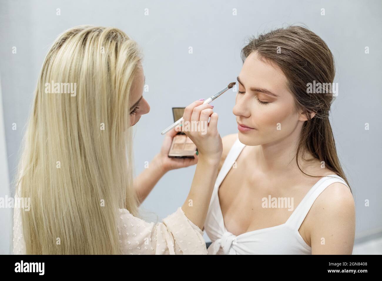 Professionelle Make-up-Künstler macht Make-up. Frau arbeitet in einem Friseursalon. Kleinunternehmen. Arbeitsplatz des Make-up-Künstlers. Stockfoto