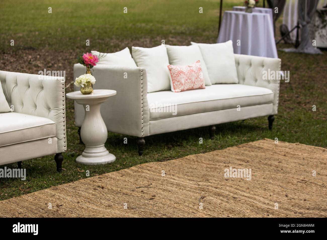Eine Party oder Hochzeit im Freien mit Möbeln wie Couch, Tisch und Blumensträußen Stockfoto