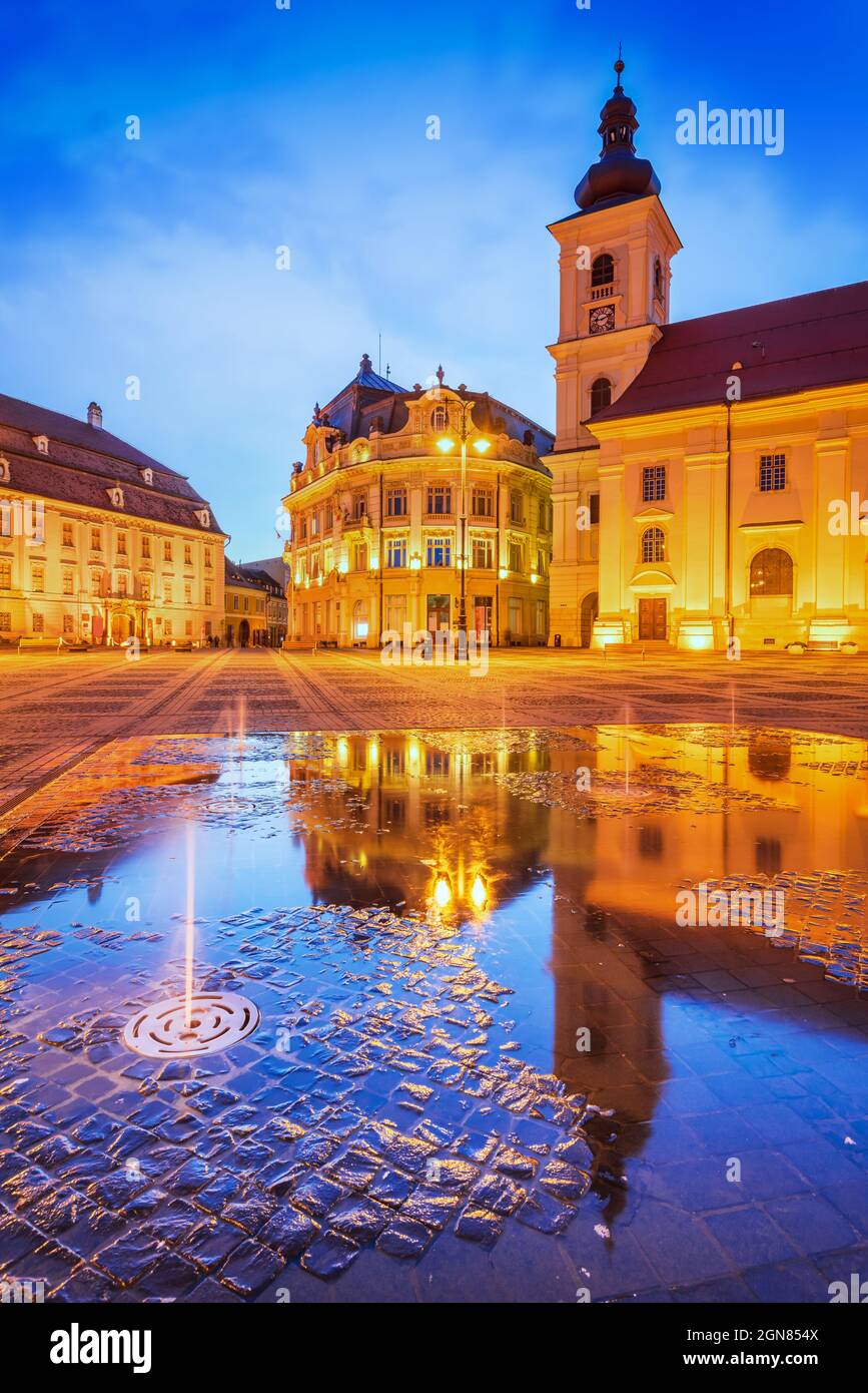 Sibiu, Rumänien. Dämmerungsszene mit Wasserspiegelung auf dem Großen Platz, Transsilvanien Reise Sehenswürdigkeit. Stockfoto