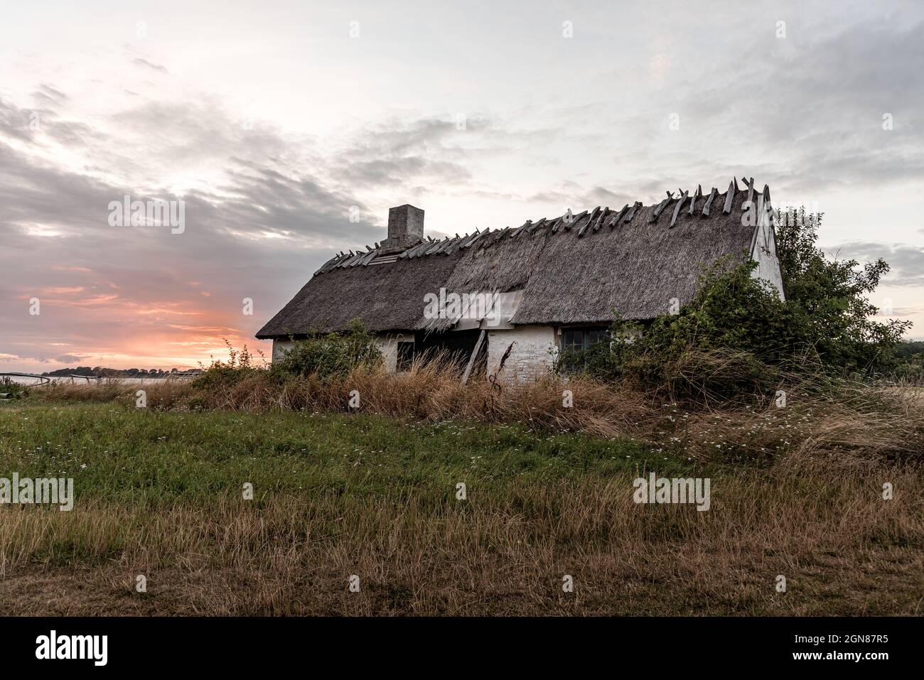Ein altes, heruntergekommenes Haus mit Reetdach, abgelegen und mit Blick auf das Meer in Bisserup, Dänemark, 8. August 2021 Stockfoto
