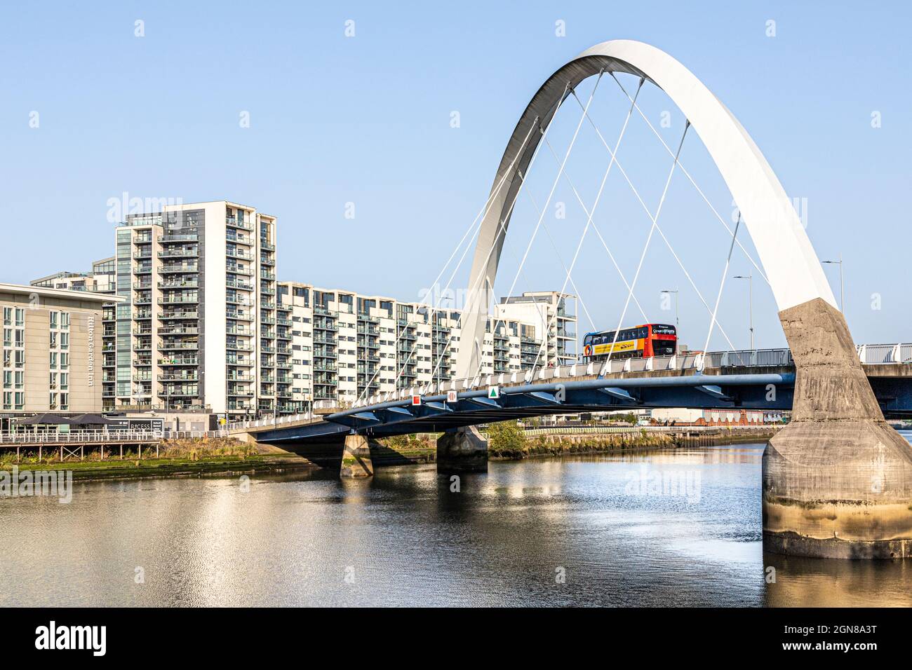 Ein Bus, der über die Clyde Arc Bridge fährt, die vor Ort als Squinty Bridge bekannt ist, über den Fluss Clyde in Glasgow, Schottland, Großbritannien Stockfoto