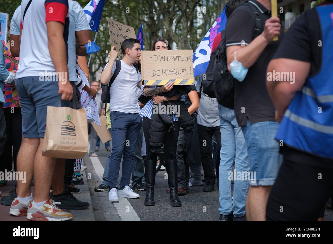 Toulouse, Frankreich. September 2021. Demonstrator mitten in der Menge mit einem Schild "weniger Animatoren, mehr Risiken" (Moins d'animateurs, plus de risques). In Toulouse (Frankreich), nur drei Wochen nach Beginn des Schuljahres, demonstrierten die Lehrer am 23. September 2021. Auf Aufruf der Hauptgewerkschaften forderten sie eine Erhöhung der Löhne sowie bessere Arbeitsbedingungen. Französische Lehrer gehören zu den am niedrigsten bezahlten in den OECD-Ländern. Eine Gruppe von AESH/ATSEM nahm dann an der Prozession Teil. Foto von Patrick Batard/ABACAPRESS.COM Quelle: Abaca Press/Alamy Live News Stockfoto