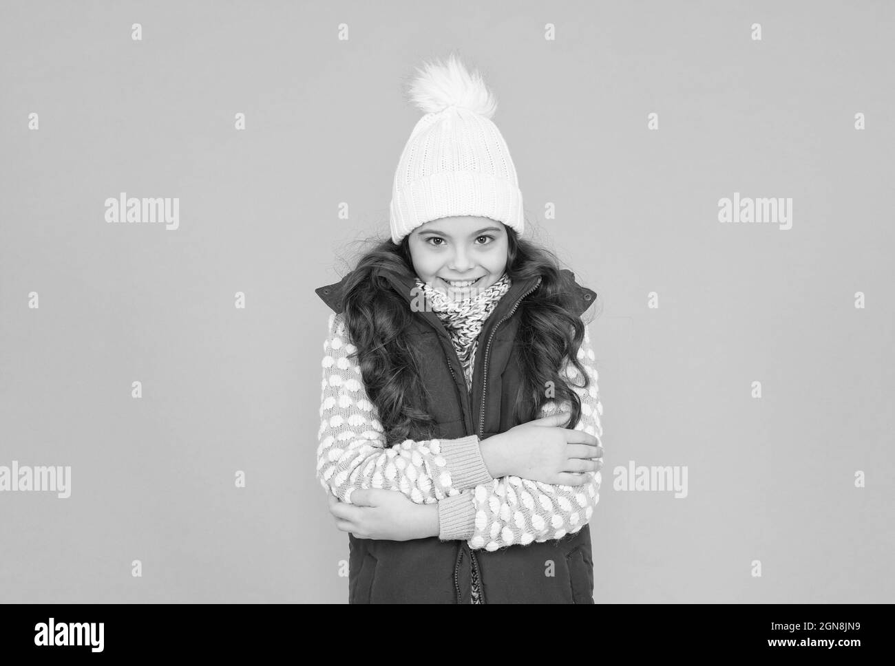 Es ist so kalt. Kindheitsglück. Thermische Kleidung. Glückliche Teenager-Mädchen tragen warme Kleidung. Winter-Kid-Mode. Kind mit langen lockigen Haaren in gestrickten Hut Stockfoto