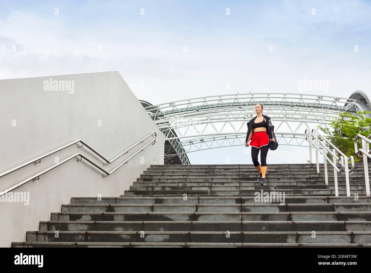 Die Sportlerin schaut weg, während sie sich auf Stufen hinunterbewegt Stockfoto