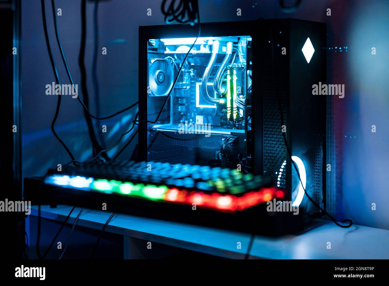 Beleuchtete Computertastatur und CPU auf dem Tisch im Studio Stockfoto
