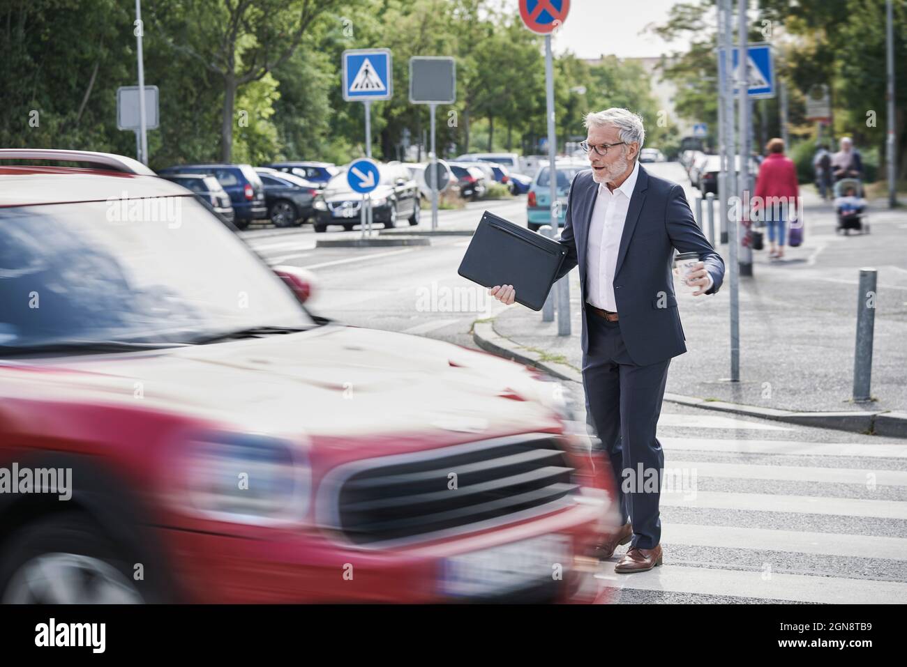 Schockiert Senior männlichen professionellen Überfahrt durch rasenden Auto Stockfoto