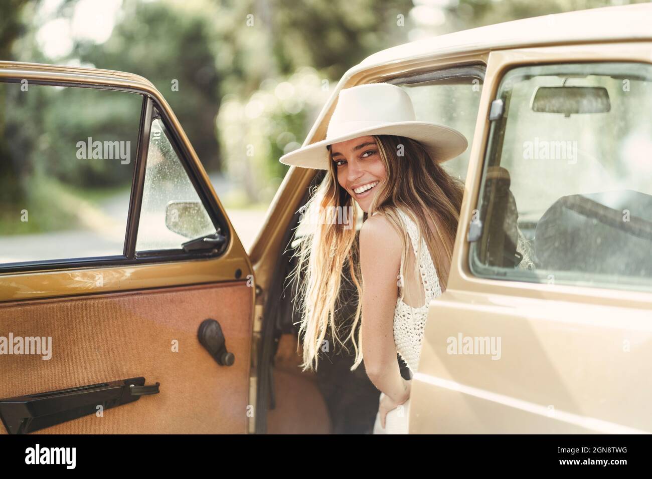 Lächelnde, schöne Frau, die im Auto über die Schulter schaut Stockfoto Lächelnde, schöne Frau, die im Auto über die Schulter schaut Stockfoto