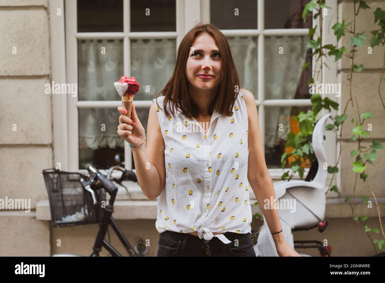 Lächelnde junge Frau mit Eis auf der Nase Stockfoto