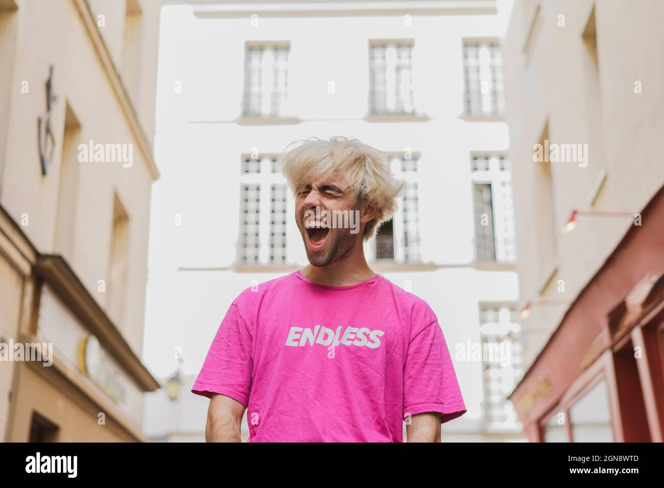 Junger Mann in pinkem T-Shirt schreiend Stockfoto