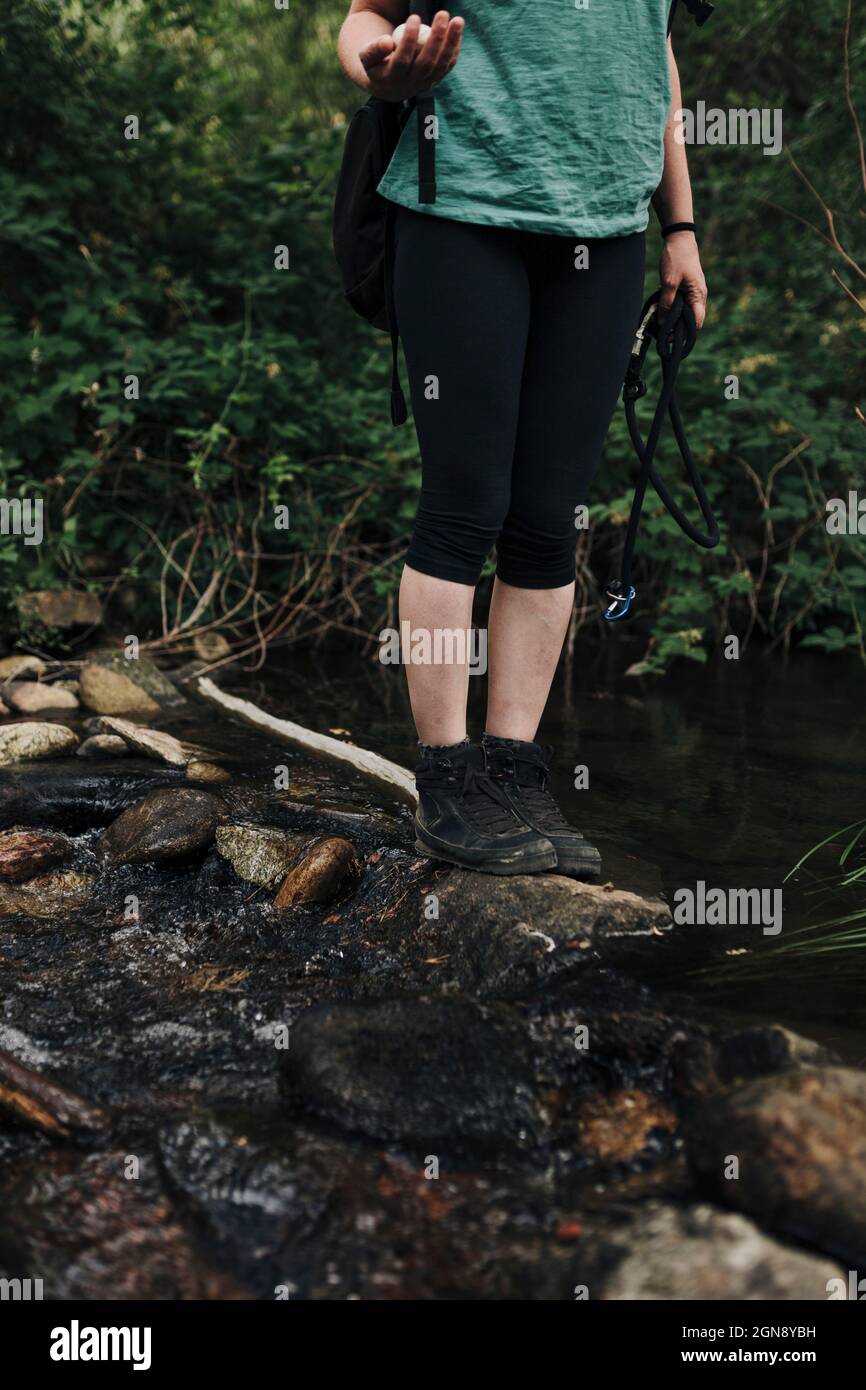Frau mittleren Erwachsenen, die auf Stein im Wald steht Stockfoto