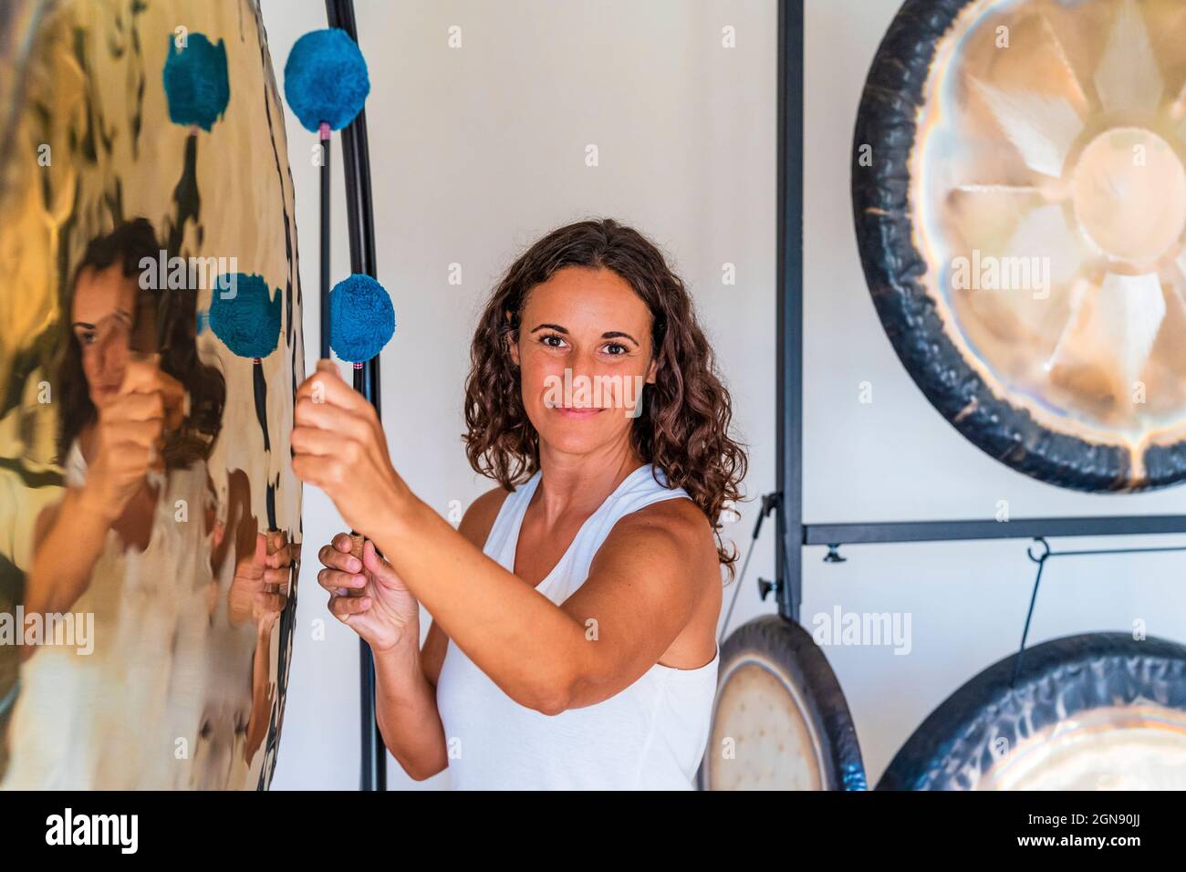 Tontherapeutin spielt gong mit Schlägerchen im Studio Stockfoto