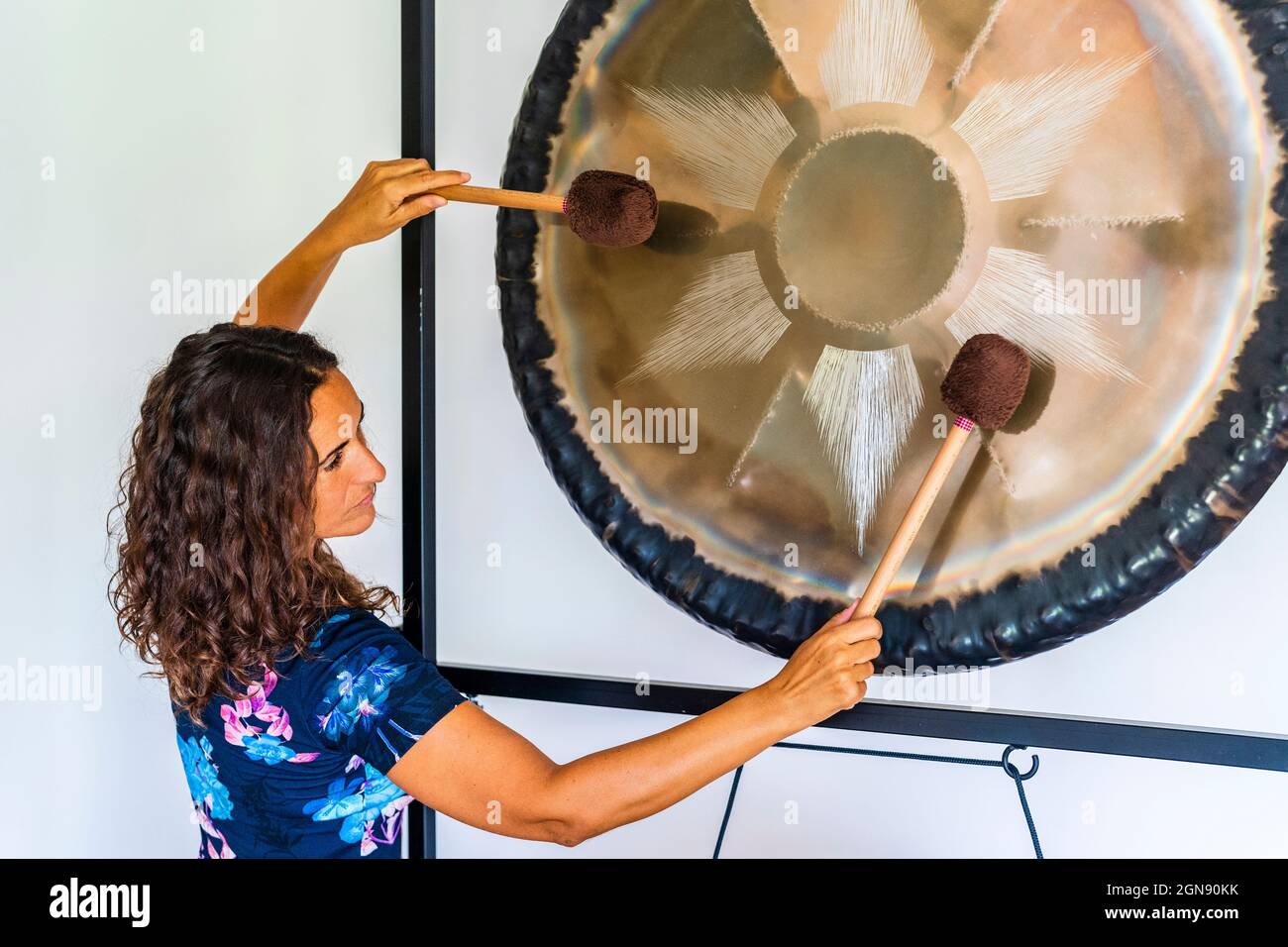 Tontherapeutin spielt gong mit Schlägerchen im Studio Stockfoto