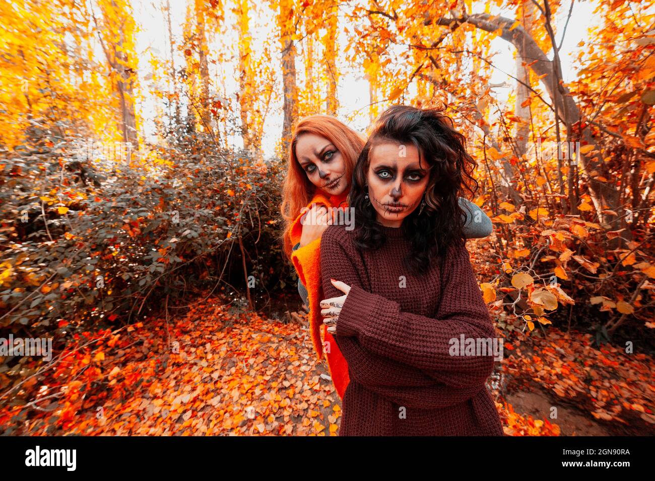 Freunde mit gruseligen Make-up stehen an Halloween im Wald Stockfoto