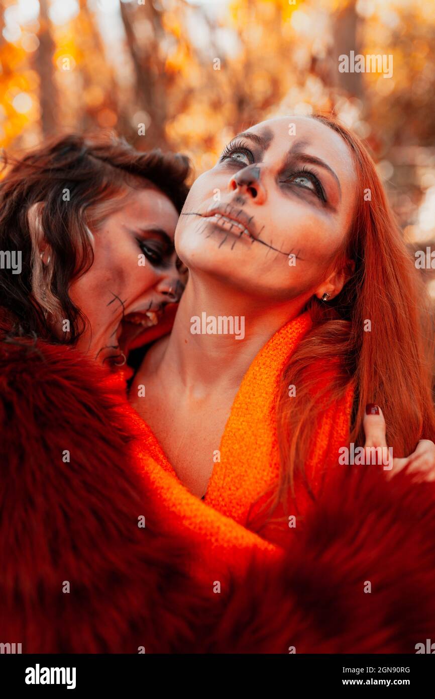 Frau mit offenem Mund umarmt Freund während Halloween Stockfoto