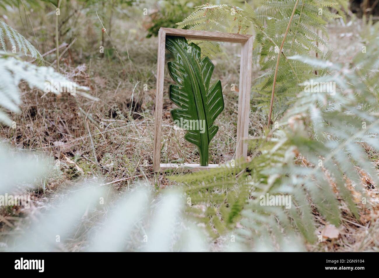Künstliches grünes Blatt im Holzrahmen am Wald Stockfoto