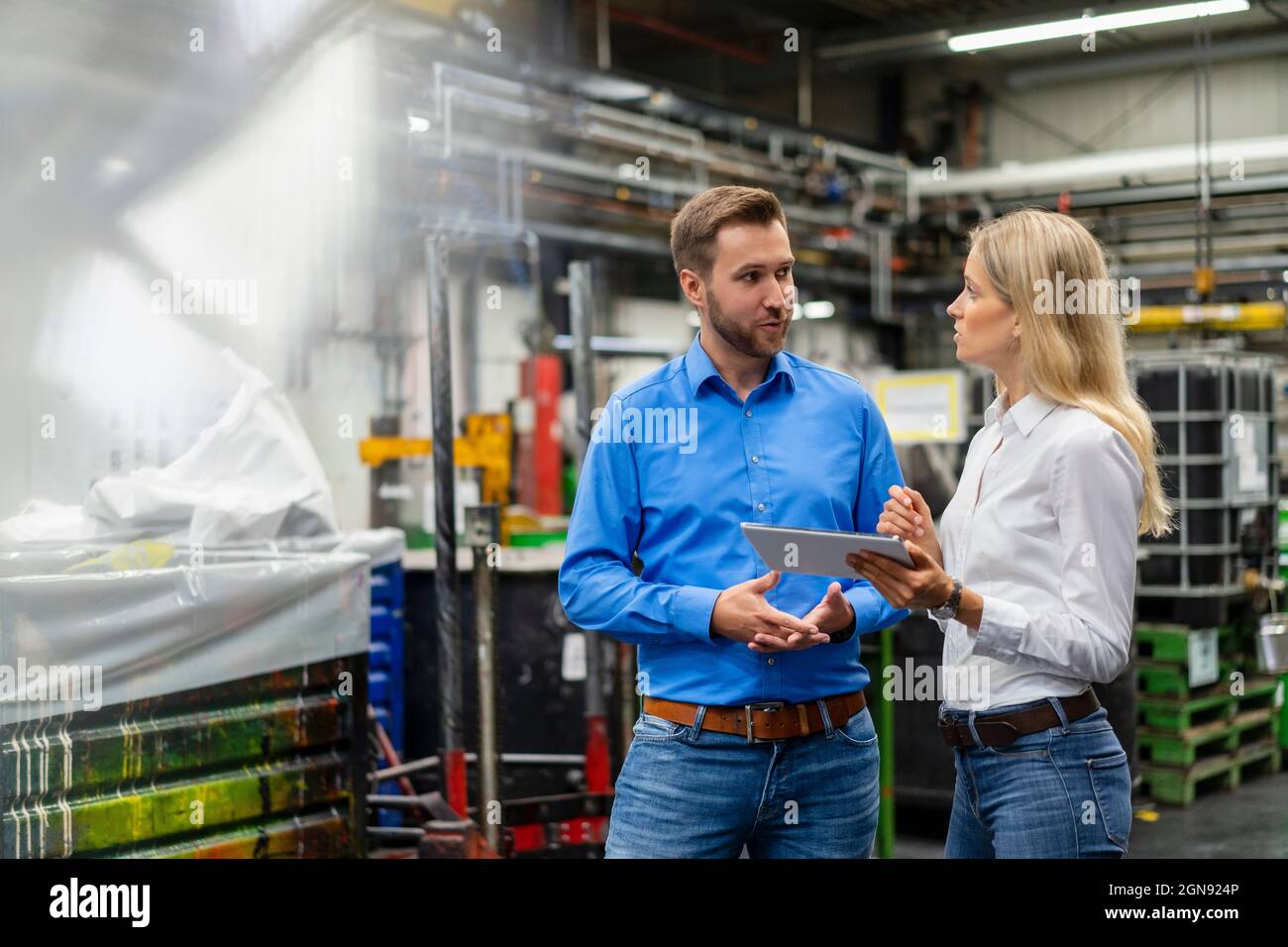 Geschäftsleute mit digitalen Tablets diskutieren in der Branche Stockfoto