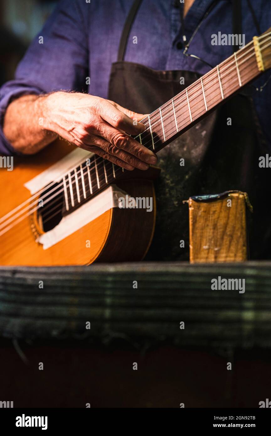 Leitender männlicher Handwerker, der in der Werkstatt Gitarre machte Stockfoto
