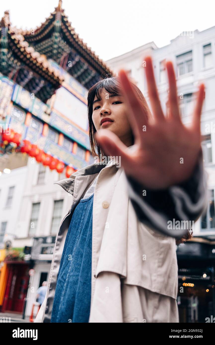 Junge Frau gestikuliert Stoppschild in der Stadt Stockfoto