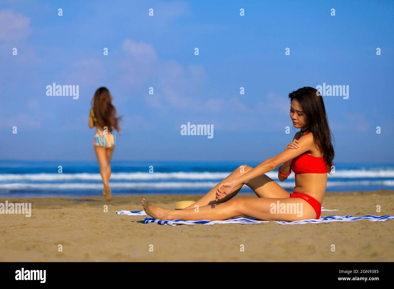 Frau, die am Strand Sonnencreme angesetzt hat Stockfoto