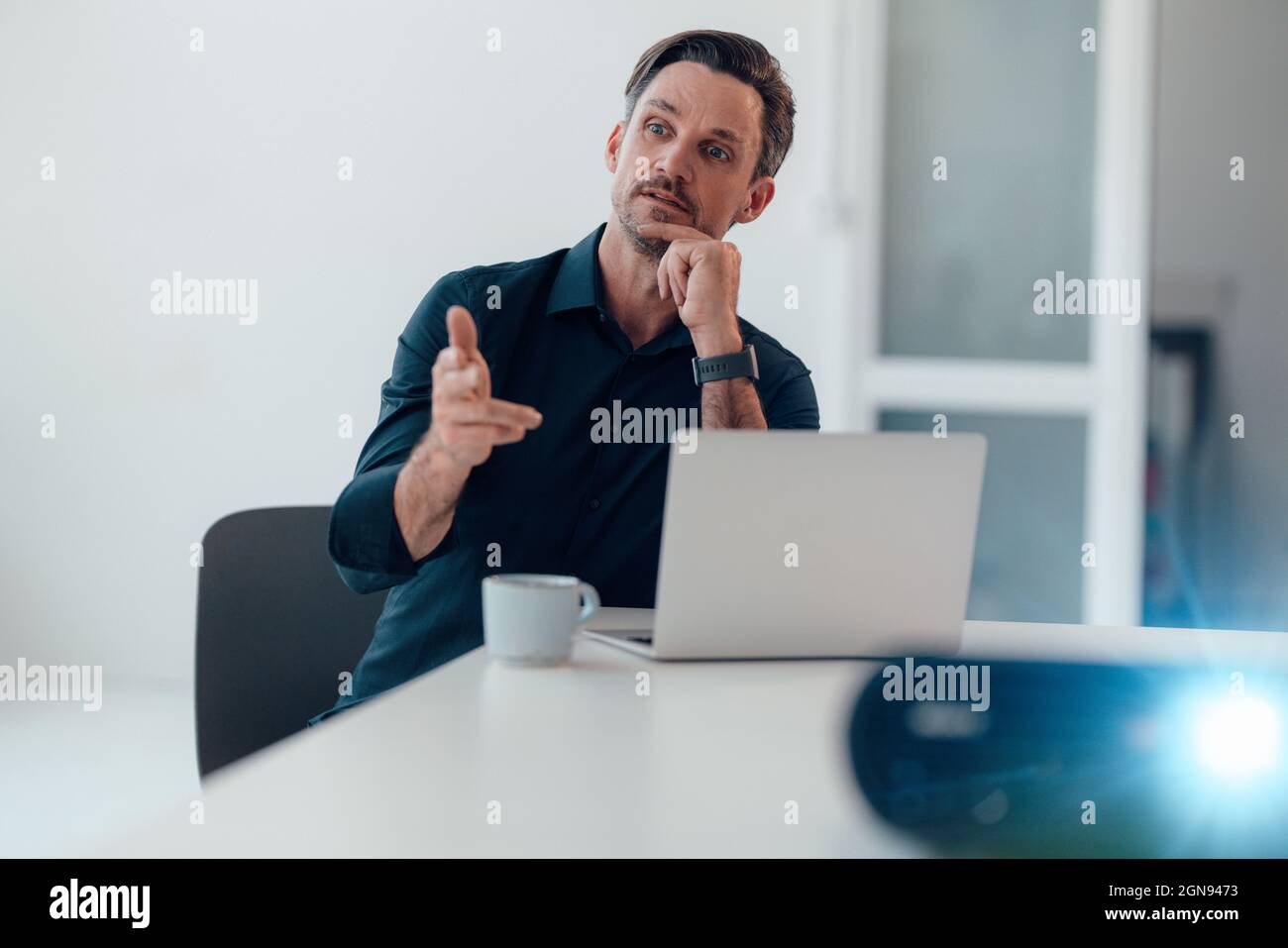 Lächelnder Geschäftsmann mit digitalem Tablet während der Präsentation im Konferenzraum Stockfoto