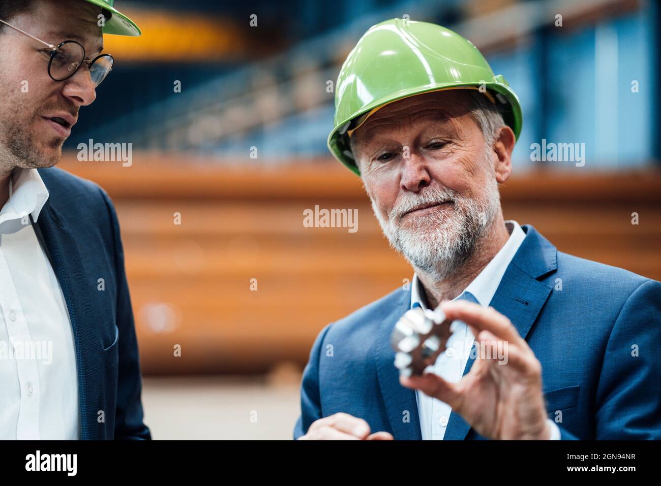 Männliche Profis mit Hardhut stehen in der Metallindustrie Stockfoto