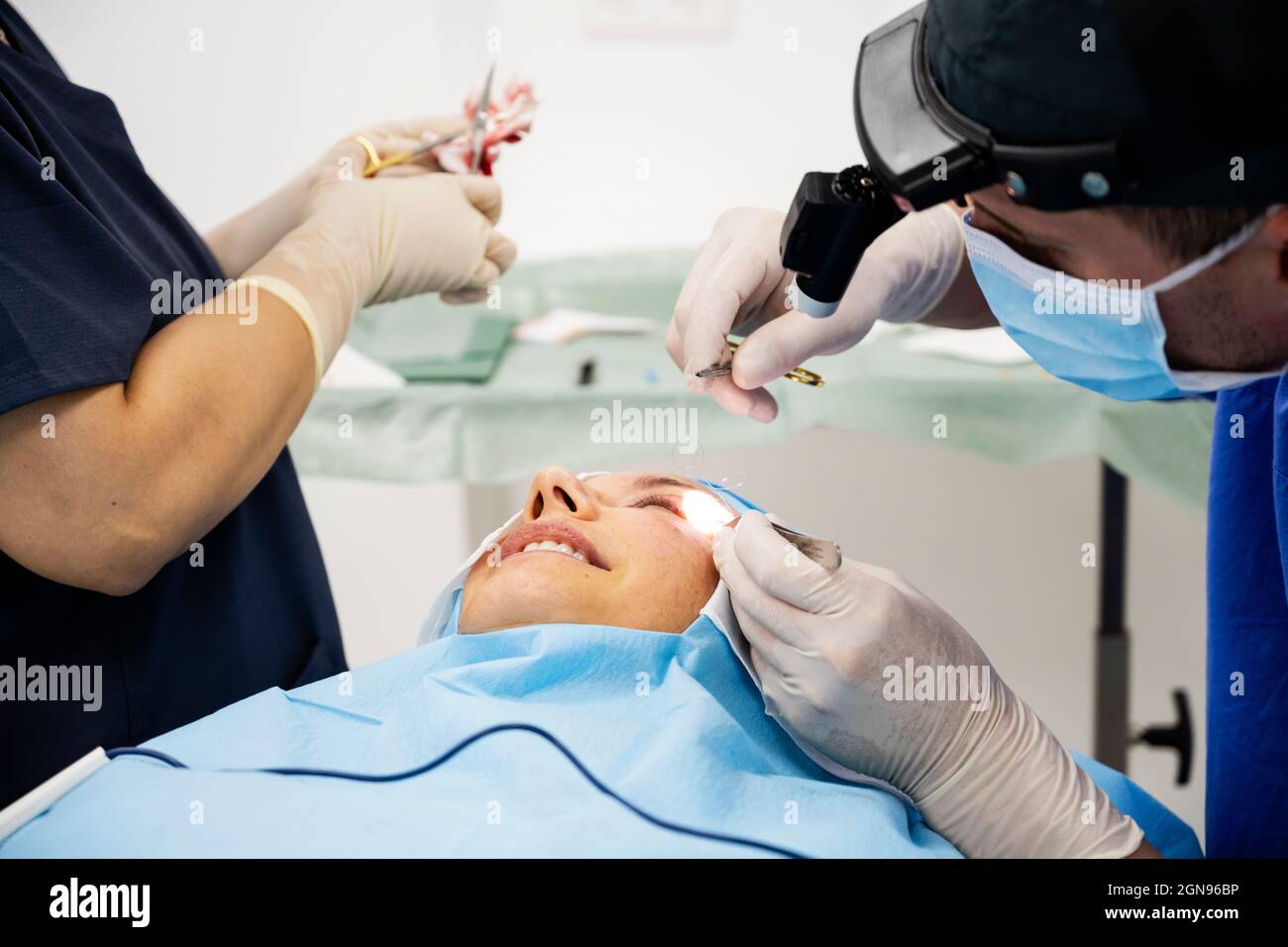 Der Chirurg näht das Augenlid nach einer plastischen Operation Stockfoto