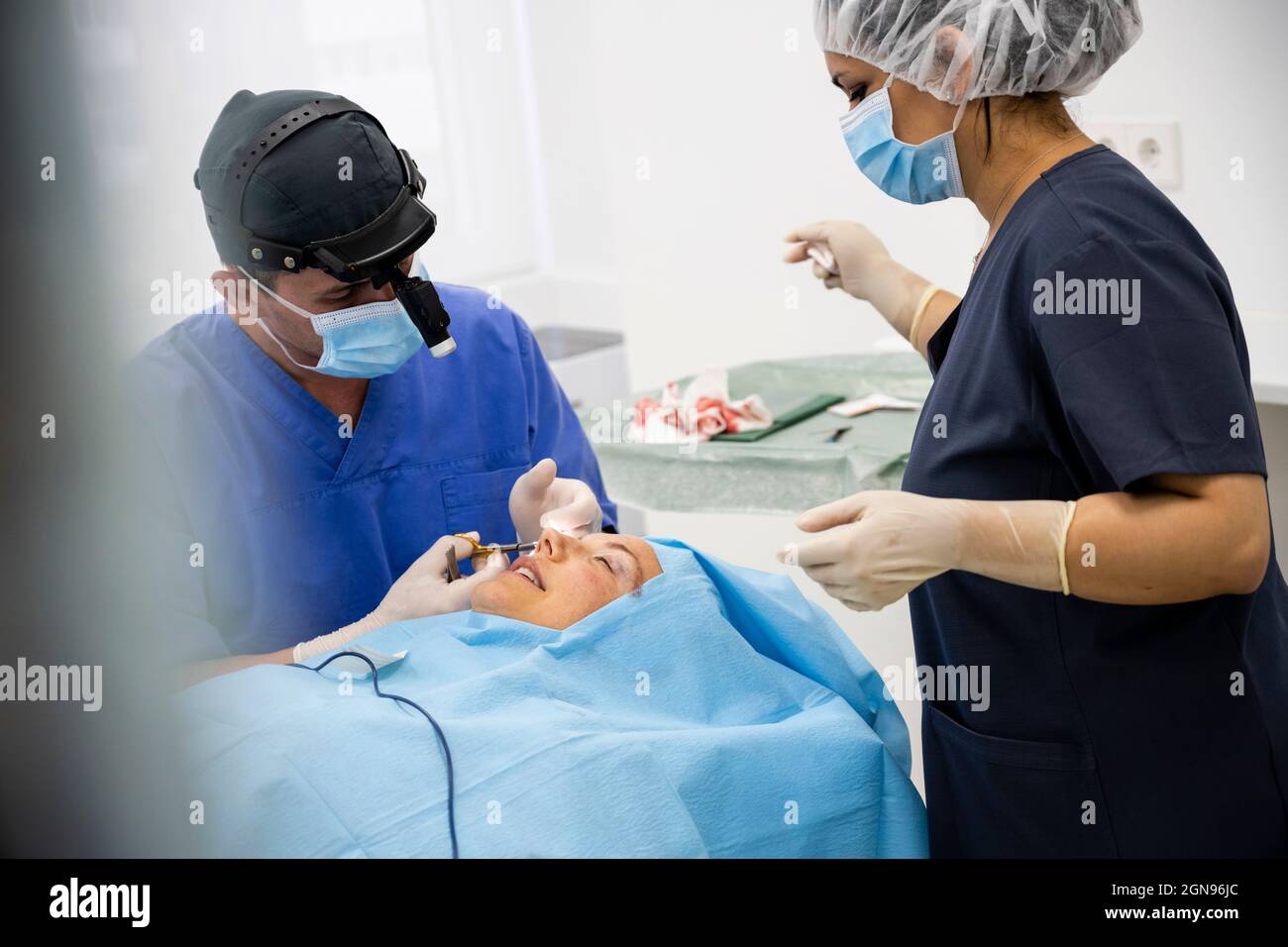 Der Chirurg näht das Augenlid nach einer plastischen Operation Stockfoto